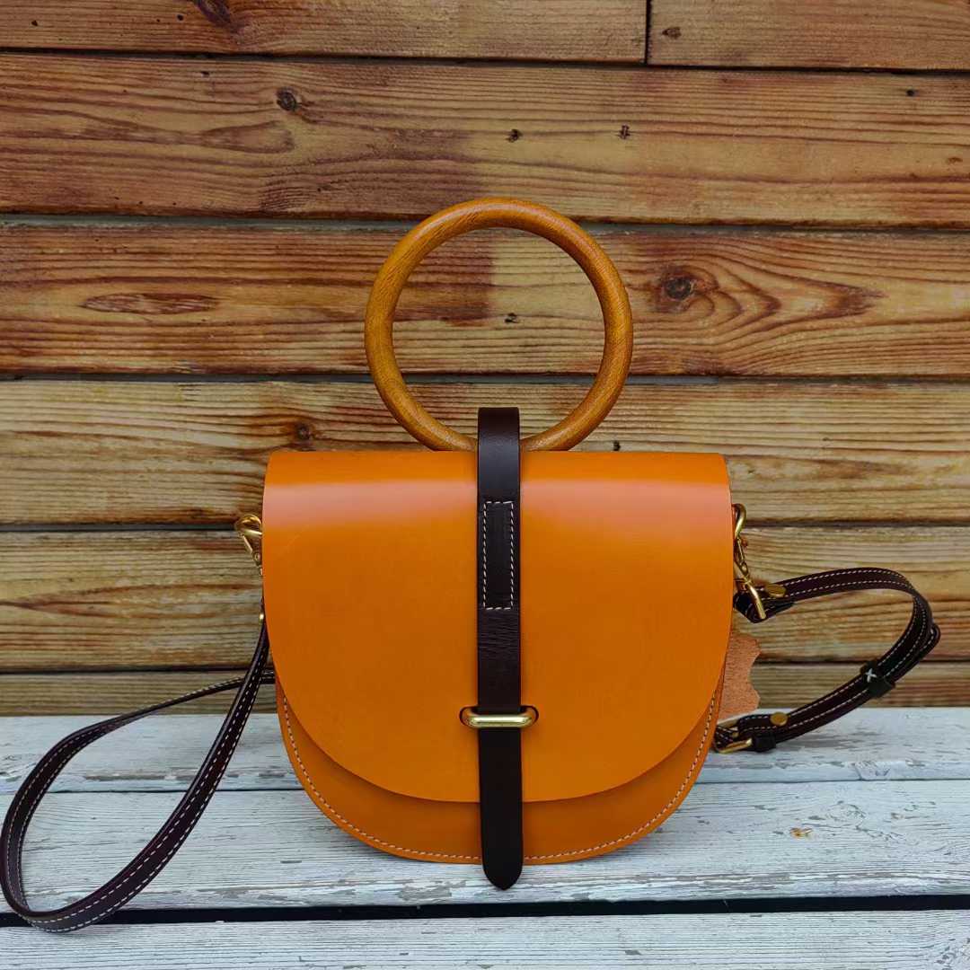 Orange leather bag front view with wooden ring handle
